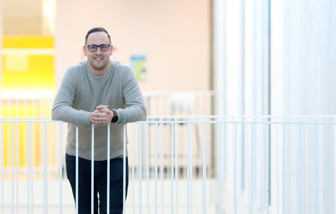 Dr. Kyle Duncan, a VIU Chemistry Professor, smiles while leaning against a white railing.
